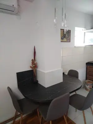 a kitchen with a black table and chairs at Apartmani Pause in Niš