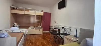 a small room with a bunk bed and a table at Apartmani Pause in Niš