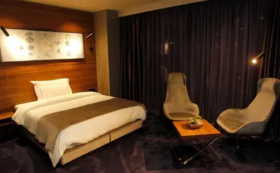 a hotel room with a bed and two chairs at Ambasador Hotel in Niš