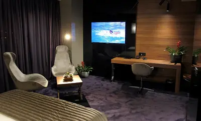 a hotel room with a bed and a desk and a tv at Ambasador Hotel in Niš