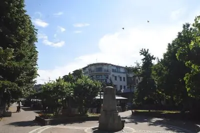 a building with a statue in the middle of a street at Apartman LM in Vrnjačka Banja