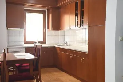 a kitchen with wooden cabinets and a table and a window at Apartman LM in Vrnjačka Banja