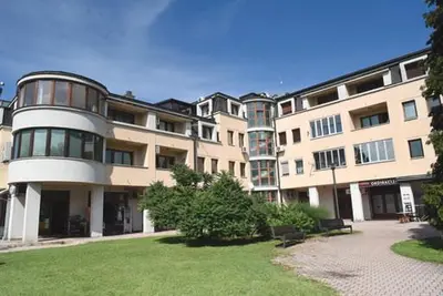 a large building with a lawn in front of it at Apartman LM in Vrnjačka Banja