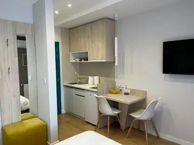 a small kitchen with a small table and chairs at PRONTO apartman & PRONTO studios in Kruševac