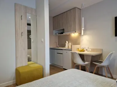 a kitchen with a table and chairs in a room at PRONTO apartman & PRONTO studios in Kruševac