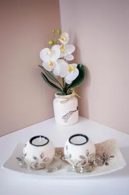 a white vase with flowers in it on a table at Venus in Niš