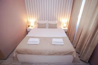 a bedroom with a large bed with two towels on it at Venus in Niš