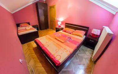 a pink bedroom with two beds in a room at Apartmani Bellini in Soko Banja