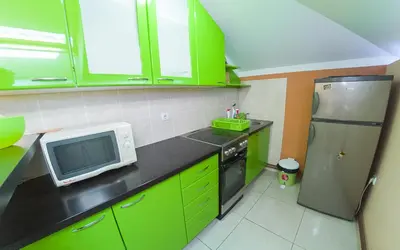 a kitchen with green cabinets and a refrigerator at Apartmani Bellini in Soko Banja