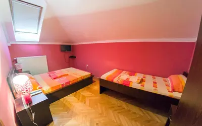 two beds in a room with red walls at Apartmani Bellini in Soko Banja