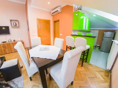 a dining room with a table and white chairs at Apartmani Bellini in Soko Banja