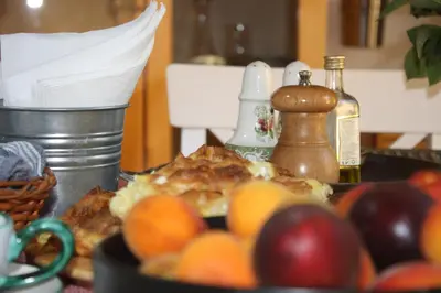 a table topped with a plate of food with fruit at Guesthouse Silvani in Kruševac