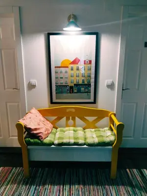 a bench in a room with a picture on the wall at Guesthouse Silvani in Kruševac