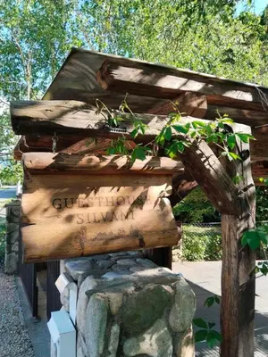 a wooden structure with a sign on top of a rock at Guesthouse Silvani in Kruševac