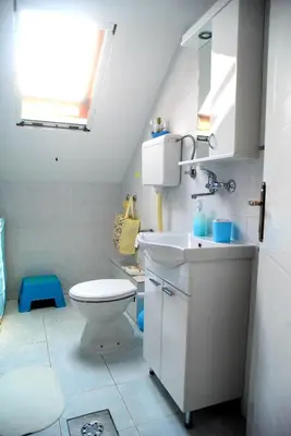 a white bathroom with a toilet and a sink at Paradise in Vrnjačka Banja