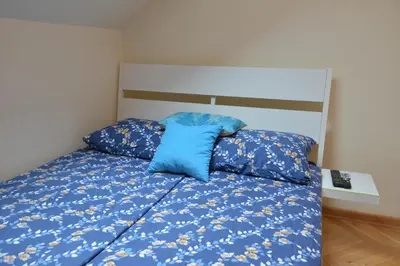 a bedroom with a bed with blue comforter at Paradise in Vrnjačka Banja