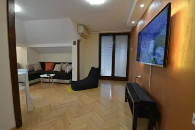 a living room with a couch and a tv on a wall at Paradise in Vrnjačka Banja