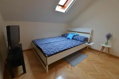 a bedroom with a bed with blue pillows and a television at Paradise in Vrnjačka Banja