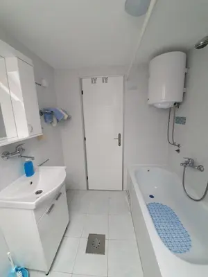 a white bathroom with a sink and a bath tub at Paradise in Vrnjačka Banja