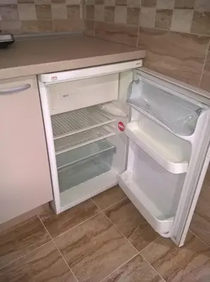 an empty refrigerator with its door open in a kitchen at Apartmani Mimi in Soko Banja