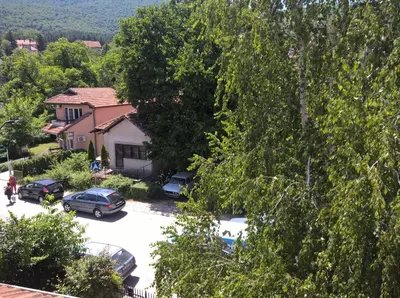 a house with cars parked in a parking lot at Apartmani Mimi in Soko Banja