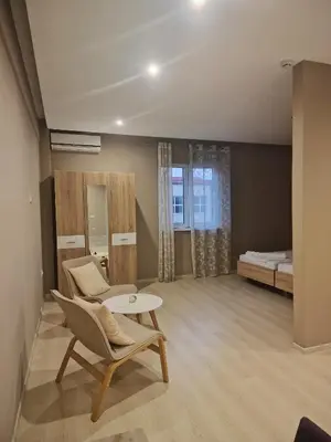 a living room with a bed and a table and chairs at VILIN in Niš