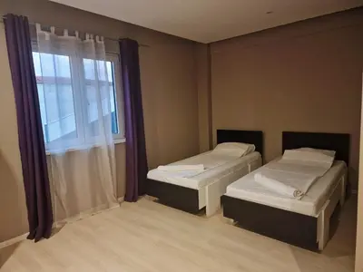 two beds in a room with a window at VILIN in Niš