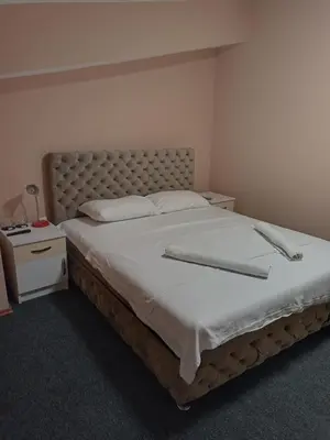 a bedroom with a large bed with white sheets at VILIN in Niš