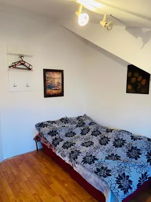 a bedroom with a bed in the corner of a room at DUŠICA APARTMANI in Jagodina