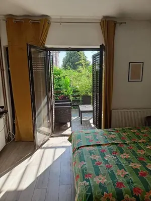 a bedroom with a bed and a sliding glass door at DUŠICA APARTMANI in Jagodina