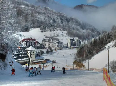 a group of people skiing down a snow covered mountain at Uni Kop in Brzeće