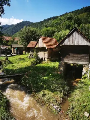 a couple of buildings sitting next to a river at Uni Kop in Brzeće