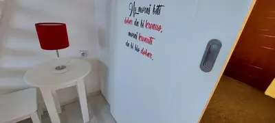 a room with a table and a red lamp on a wall at Uni Kop in Brzeće