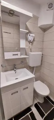 a bathroom with a white sink and a toilet at Uni Kop in Brzeće
