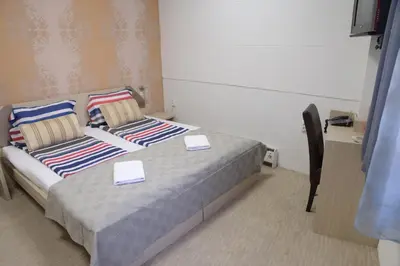 a bedroom with a bed with two cards on it at Guest House GOLDEN COIN in Niš
