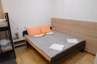 a bed with two pillows on it in a room at Guest House GOLDEN COIN in Niš