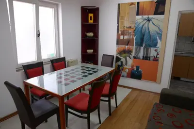 a dining room with a table and chairs at Guest House GOLDEN COIN in Niš