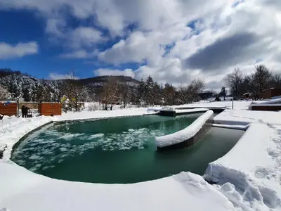 a pool of water with snow on the ground at Hotel Ramonda in Boljevac