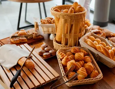 a table with baskets of pastries and other pastries at Hotel Ramonda in Boljevac