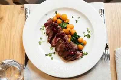 a plate of food with meat and vegetables on a table at Hotel Ramonda in Boljevac