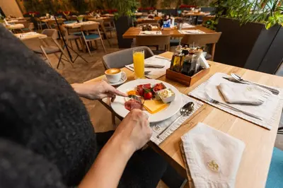 a person sitting at a table with a plate of food at Hotel Ramonda in Boljevac