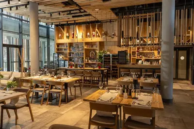 a restaurant with wooden tables and chairs and windows at Hotel Ramonda in Boljevac