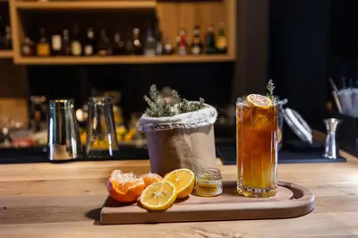 a wooden table with two drinks and orange slices at Hotel Ramonda in Boljevac