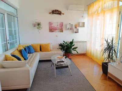a living room with a white couch and a glass table at Vila Sentić in Vranje