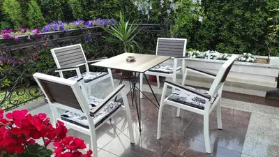 a table and four chairs and a table and flowers at Vila Sentić in Vranje