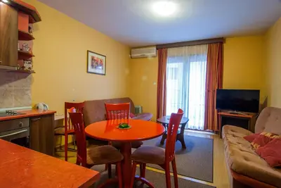 a kitchen and living room with a table and a couch at Apartments Raj in Vrnjačka Banja