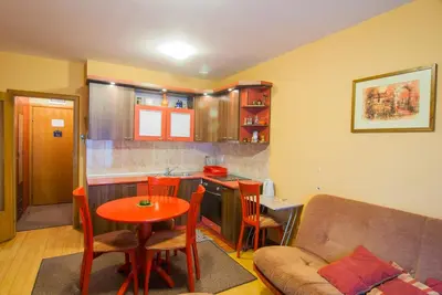 a living room with a couch and a table and a kitchen at Apartments Raj in Vrnjačka Banja