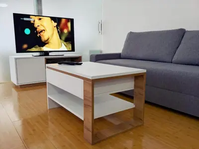 a living room with a couch and a table with a tv at Lux Studio Apartment Vidanovic in Pirot
