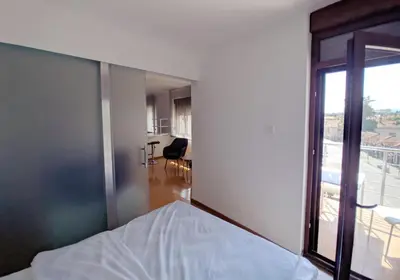 a bedroom with a bed and a large window at Lux Studio Apartment Vidanovic in Pirot