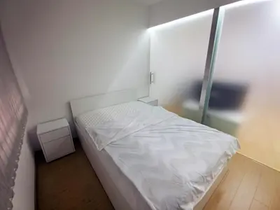 a small bedroom with a white bed and a mirror at Lux Studio Apartment Vidanovic in Pirot